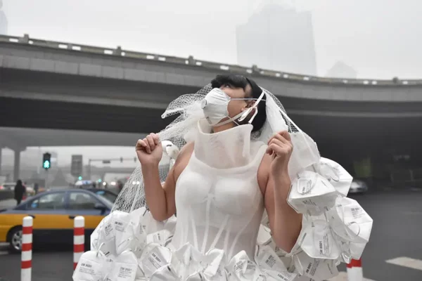 Pechino, Cina L'artista Kong Ning indossa un abito da sposa fatto di respiratori per sottolineare le preoccupazioni sulla qualità dell'aria e sull'inquinamento. Fotografia/ Luo Xiaoguang Xinhua Press Corbis